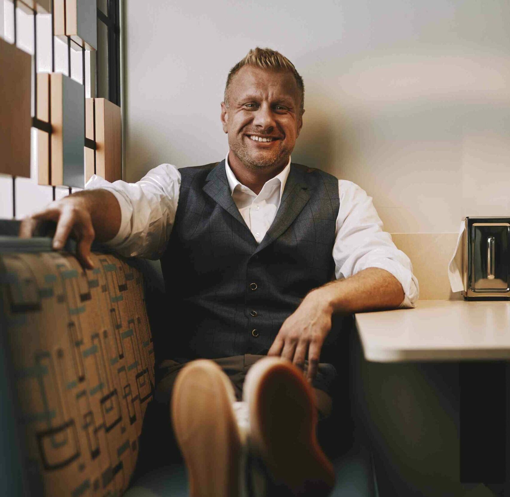 Matt Tompkins seated in a booth smiling